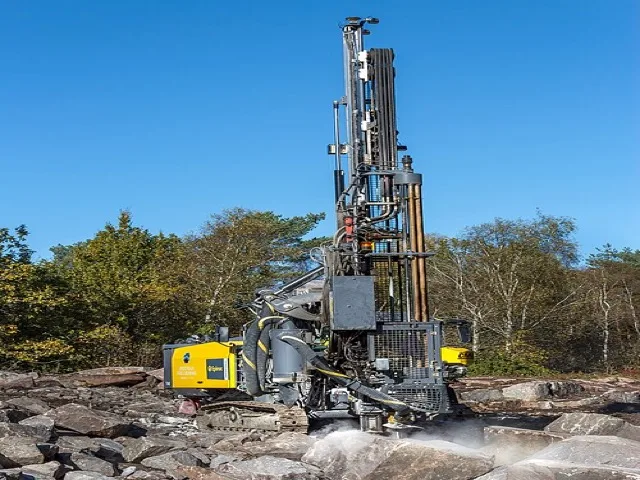 Modern rotary fúróberendezés kőzettörmeléken, sárga vázas kivitelben